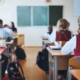 Students In Uniforms Studying In Classroom
