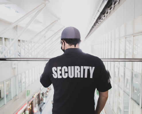 Security Guard In Uniform Patrolling In A Commercial Building